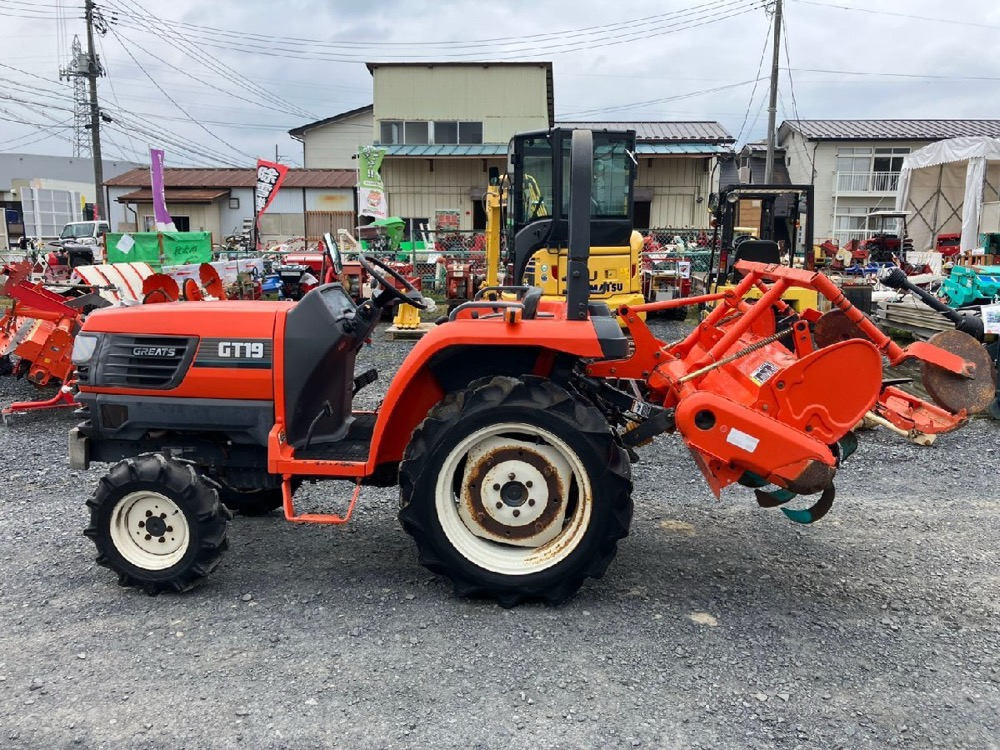 Kubota GT19 4WD compact tractor with rotary tiller, side view